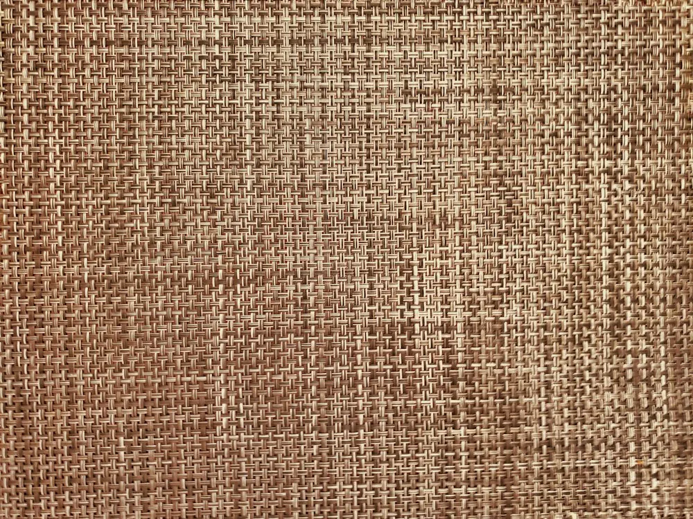 Tissage serré de fibres naturelles brunes et beiges, vu de près.